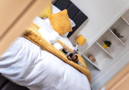 科特布里奇Albion Apartment by Klass Living Coatbridge的一间卧室配有带白色床单和黄色枕头的床。
