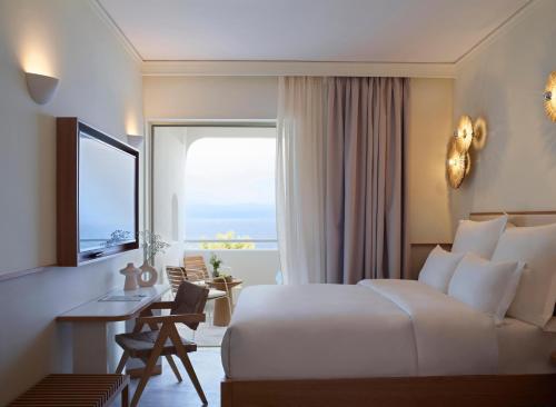 哈尔基斯Brown Beach Chalkida, a member of Brown Hotels的配有一张床、一张书桌和一扇窗户的酒店客房
