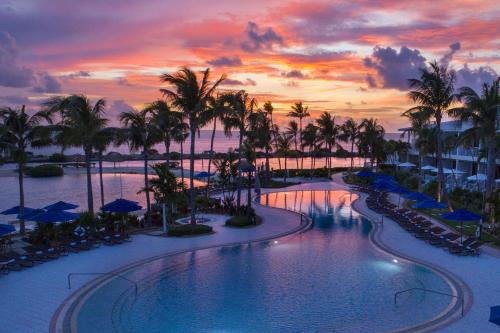 鸭礁岛Villas at Hawks Cay Resort的棕榈树和日落的度假村游泳池