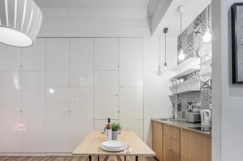 布达佩斯Extra Central Modern Studio的厨房设有白色的墙壁和木桌