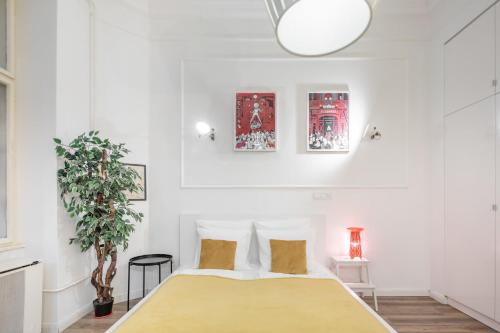 布达佩斯Extra Central Modern Studio的一间卧室配有一张床和盆栽植物