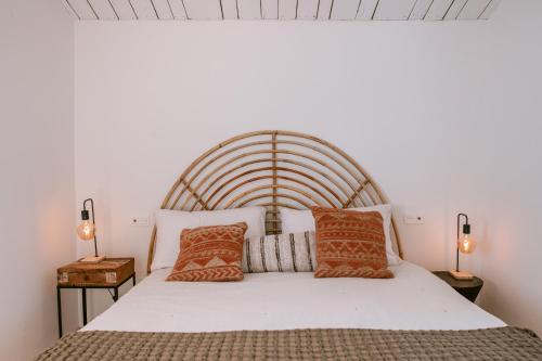 蒙达San Roque Suites de Monda的一间卧室配有一张带两盏灯的大型白色床。