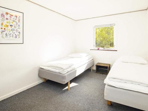 莱斯Holiday home Læsø的白色的客房设有两张床和窗户。