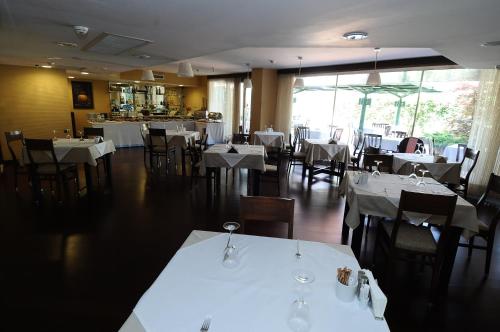 安卡拉翁图尔布提克酒店的一间设有白色桌椅的用餐室和一间餐厅