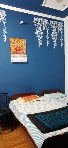 大诺伊达Balaji Guest House - Home Stay的客房内的蓝色墙壁和床
