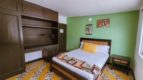 佩雷拉Tuki Hostel & Lounge的一间小卧室,配有床和绿色的墙壁