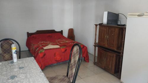 米纳斯Apartamento jorge lopez的一间卧室配有一张床、一张桌子和一个梳妆台