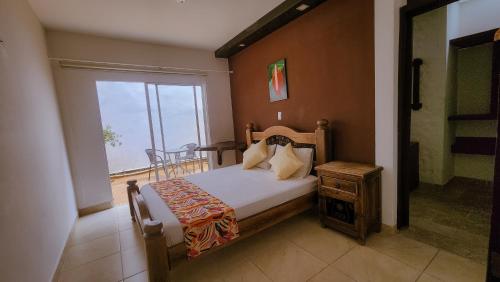 佩雷拉Tuki Hostel & Lounge的一间卧室设有一张床、一个窗口和一张桌子