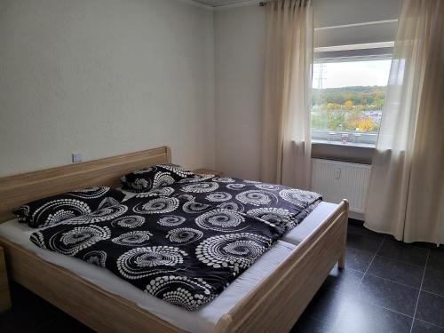 萨尔布吕肯schöne, modernisierte Wohnung - Dudweiler的一间卧室配有一张带黑白毯子的床