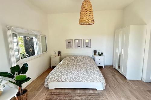 蒙彼利埃Maison, 2chambres, jardin, parking, central,6pers的一间卧室配有一张床和盆栽植物