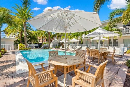克利尔沃特Hotel Cabana Clearwater Beach的游泳池旁带遮阳伞的桌子