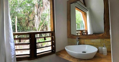 玛雅湾Kin Resort Lodge的一间带水槽和镜子的浴室以及窗户。