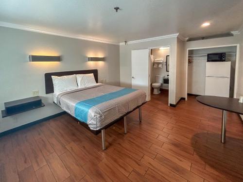 安大略加利福尼亚安大略6号汽车旅馆的一间卧室配有一张床和一张桌子