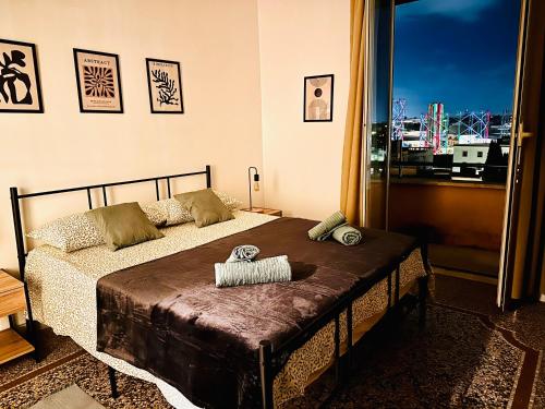 罗马Attico lussuoso Roma centro的一间卧室设有一张床和一个大窗户