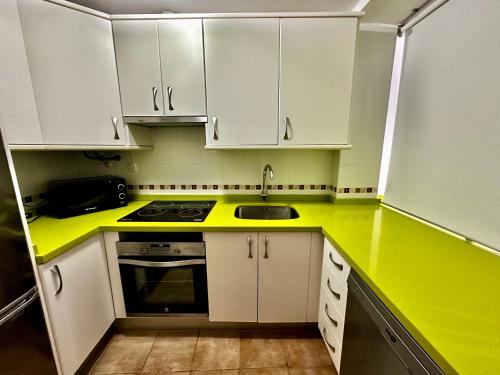 内尔哈Apartamento E&D的厨房配有黄色台面和白色橱柜