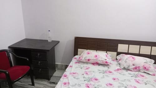 加雅Darbar Homestay的一间卧室配有一张床和一个粉红色鲜花梳妆台。