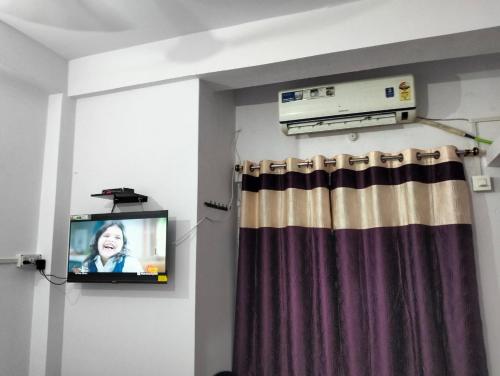 加雅Darbar Homestay的窗帘间里的电视