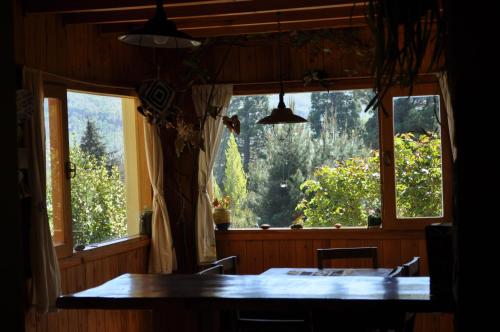 圣马丁德洛斯Melodia natural en San Martín de los Andes的一间带桌子和大窗户的用餐室