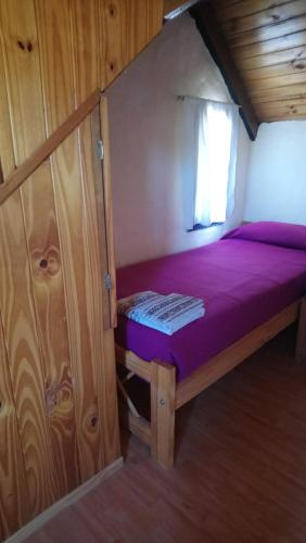 胡宁德洛斯安第斯El Tranco - Casa "Tu Lugar"的小屋内的小卧室配有紫色床