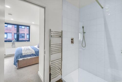 贝德福德Contractors Gem, 2 bed, sleeps 6, bathroom & ensuite的一间带步入式淋浴间的浴室,位于床边