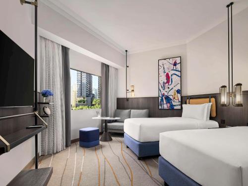新加坡Pullman Singapore Orchard的酒店客房,设有两张床和一张沙发