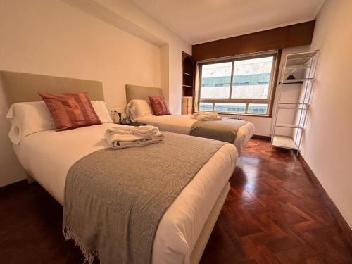 拉科鲁尼亚Oktheway Big Coruña的一间卧室设有两张床和窗户。