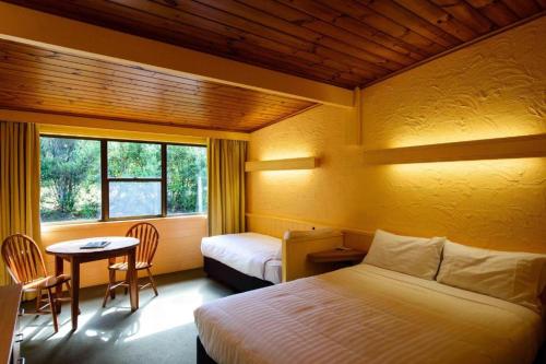 斯特拉恩斯特拉汉村酒店的一间卧室设有两张床、一张桌子和一个窗口