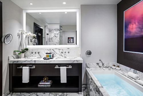 拉斯维加斯Red Rock Casino Resort & Spa的一间带大浴缸和大镜子的浴室