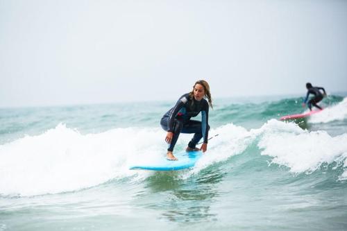阿加迪尔Surf Lessons Experience with Hassi的一名在海上冲浪板上挥舞的女人