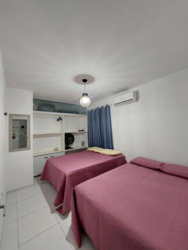 皮帕Zapipou - Apartamento aconchegante para você aproveitar o melhor de Pipa的卧室内的两张床,配有粉红色的床单
