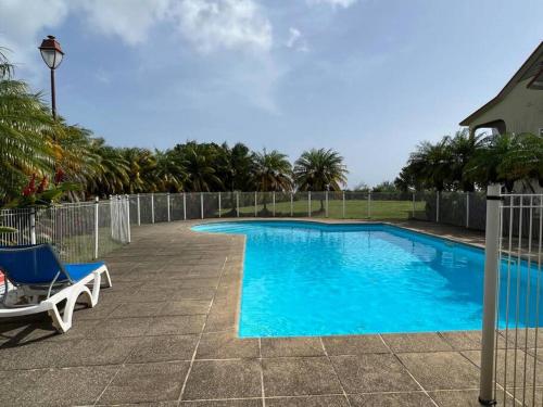 圣克洛德KANOA LODGE piscine et vue mer的一个带椅子和围栏的蓝色游泳池