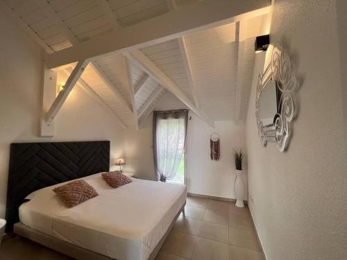 圣克洛德KANOA LODGE piscine et vue mer的卧室设有一张白色大床和一扇窗户。