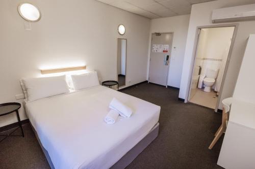 阿德莱德YHA Adelaide Central的一间带白色大床的卧室和2个卫生间