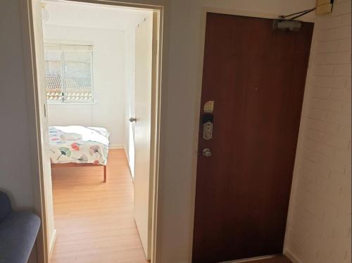 堪培拉Private Room in a 3-Bedroom Apartment-3的通往卧室的门,卧室内设有一张床