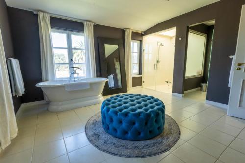 纳帕Ashe Vineyard By PHH Stays的带浴缸的浴室和一张桌子上的蓝色蛋糕