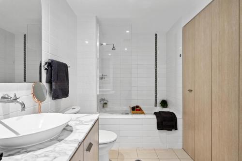黄金海岸Luxury Stays Varsity-Robina-Bond的浴室配有盥洗盆、卫生间和浴缸。