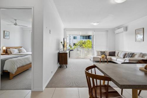 黄金海岸Luxury Stays Varsity-Robina-Bond的一间卧室配有一张床,客厅配有桌子