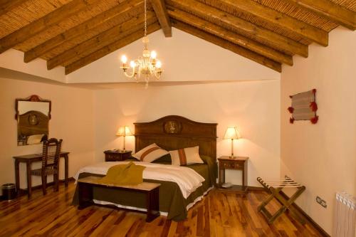 普尔马马尔卡Hotel Marqués De Tojo的一间卧室配有一张大床和一个吊灯。