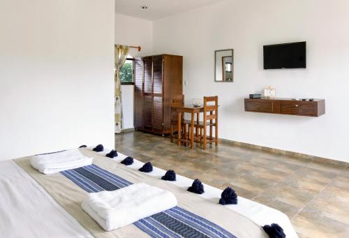 图卢姆hotel stella maris tulum的一间卧室配有一张带毛巾和桌子的床