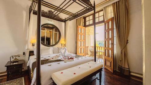 琅勃拉邦JingLand Hotel Luangprabang的一间卧室配有一张大床和镜子