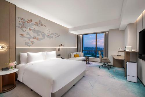 上海上海大华锦绣皇冠假日酒店的酒店客房设有一张白色大床和一张书桌