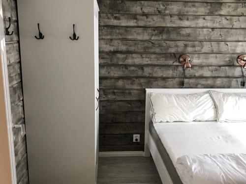 LimaHoliday home LIMA II的卧室配有白色的床和木墙