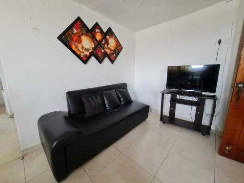 卡塔赫纳EDIFICIO MENDEZ的客厅配有黑色沙发和电视
