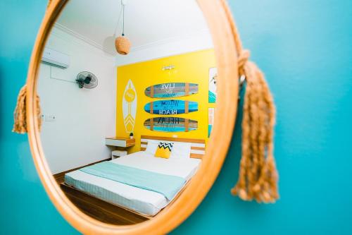 归仁Blossom Sea Homestay Quy Nhơn的镜子反射着卧室,卧室里配有一张床