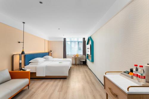 广州宜霖城际酒店(广州白云站国际单位店)的酒店客房,设有两张床和一张沙发