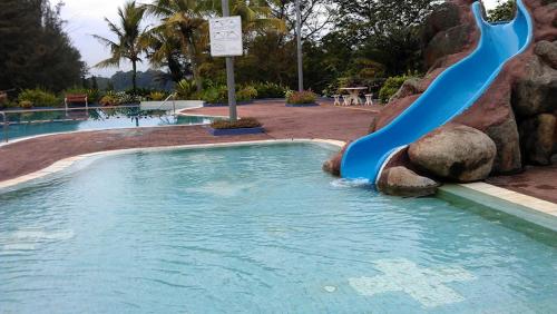 峇株巴辖Nestle Homestay@Batu Pahat的游泳池中的蓝色水滑梯