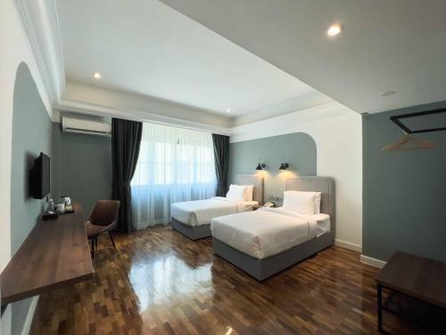 马六甲Hotel Seri Costa的酒店客房设有两张床和电视。