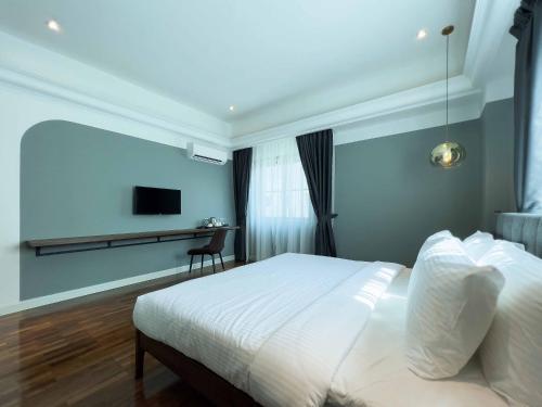马六甲Hotel Seri Costa的卧室配有白色的床和电视。