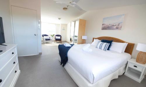尼尔森湾尼尔森湾微风度假村的卧室配有白色的床和电视。
