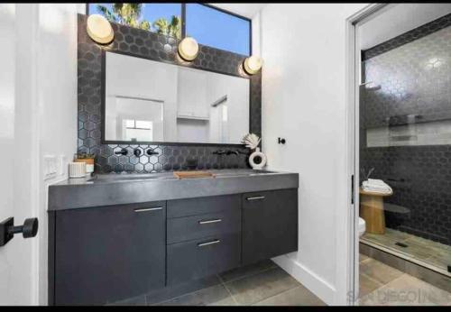 圣地亚哥La Jolla Townhouse steps away from Windansea beach的一间带水槽和大镜子的浴室